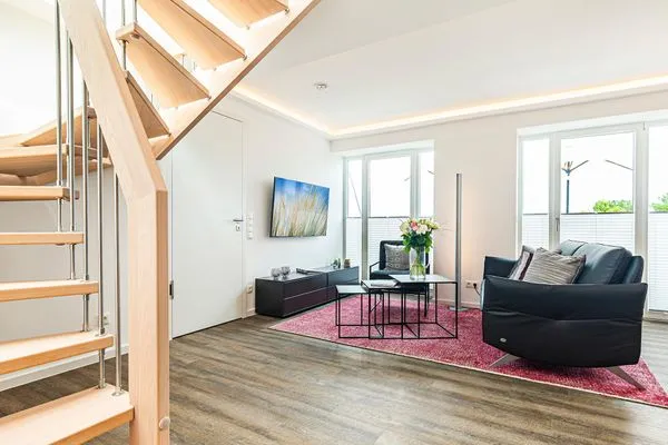 Wohnbereich/Essbereich: Sofa, TV, Beschattungs-Plissess, Treppenaufgang zur Dachterrasse, Zugang zum Balkon  FeWo Sky Lodge Dachterrasse in PRORA - 8.51b