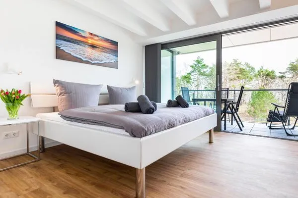 Schlafzimmer 1: Doppelbett (180x200), TV, Zugang zum Balkon, - Blick auf das Meer  FeWo Dünenheide 3.3 in PRORA - 7.33