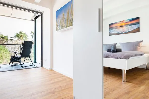 Schlafzimmer 1: Doppelbett (180x200), TV, Zugang zum Balkon, - Blick auf das Meer  FeWo Dünenheide 3.3 in PRORA - 7.33