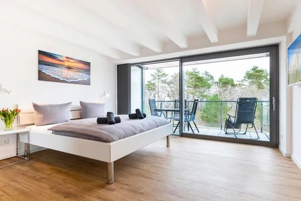 Schlafzimmer 1: Doppelbett (180x200), TV, Zugang zum Balkon, - Blick Richtung Meer  FeWo Dünenheide 3.4 in PRORA - 7.34