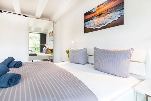 Schlafzimmer 1: Doppelbett (180x200), TV, Zugang zum Balkon, - Blick Richtung Meer  FeWo Dünenheide 3.4 in PRORA - 7.34