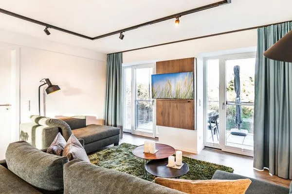 Wohn-/Essbereich: Couchgruppe mit Tisch, Smart-TV, Essbereich, Zugang zum Balkon mit Tisch und Stühlen (Seeseite), Sonne  FeWo Hideaway in PRORA - 2.45