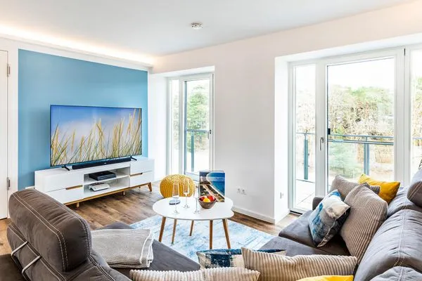 Wohnzimmer: Schlafsofa, TV, Zugang zum Balkon  FeWo Baltic Sunrise in PRORA - 3.33