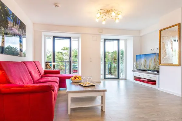 Wohnzimmer: Couch, TV, Essbereich, Zugang zum Balkon  FeWo Seeigel in PRORA - 6.34