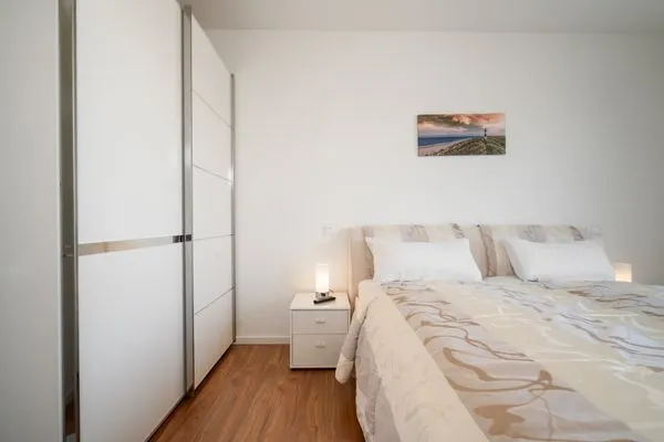Ferienwohnung Hafenblick Waren (Müritz) – Modernes Schlafzimmer mit großem Kleiderschrank und gemütlichem Doppelbett  Hafenblick