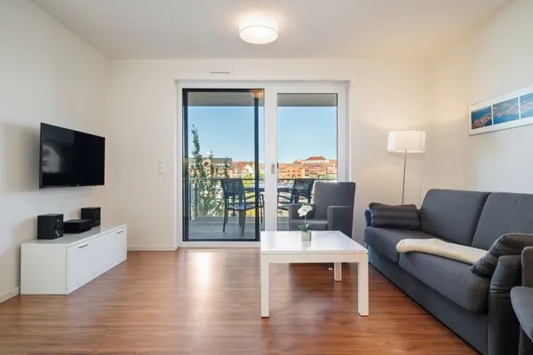 Ferienwohnung Hafenblick Waren (Müritz) – Gemütliches Wohnzimmer mit Balkonzugang und herrlichem Blick auf den Hafen  Hafenblick