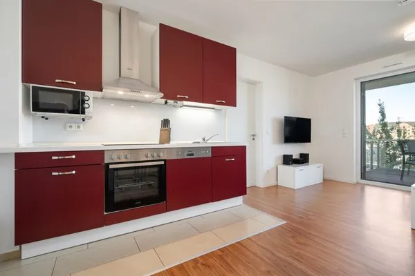 Ferienwohnung Hafenblick Waren (Müritz) – Offene Küche mit modernen Geräten und Zugang zum Balkon mit Hafenblick  Hafenblick