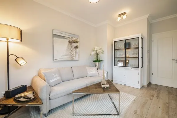 Wohnbereich mit Sofa und Vitrine Logierhaus Friedrich WE 2 - "Strandrose"