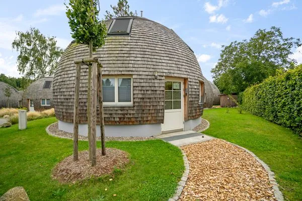Ferienhaus Nordkugel – Kugelhaus am Tollensesee – einladender Hauseingang mit Gartenweg & Naturholzfassade  Nordkugel