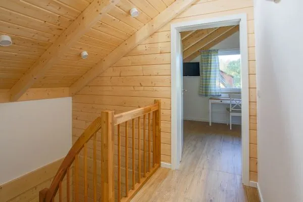 Einfamilienhaus Am Hafen 21 in Zieslow — Treppenaufgang im Dachgeschoss mit Holzverkleidung und Blick ins Schlafzimmer  Am Hafen 21