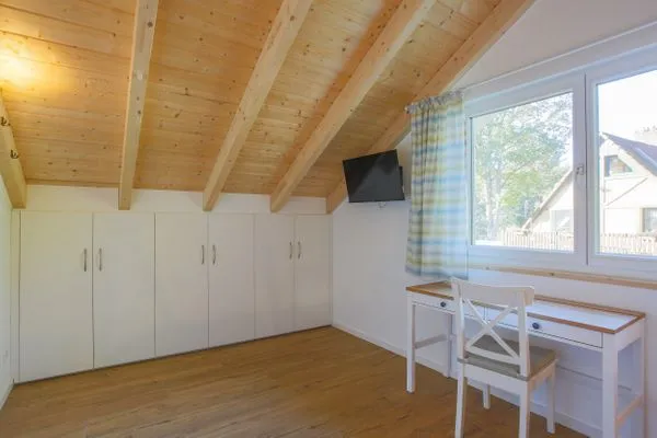 Einfamilienhaus Am Hafen 21 in Zieslow — Dachgeschosszimmer mit Einbauschränken, Schreibtisch und großem Fenster  Am Hafen 21