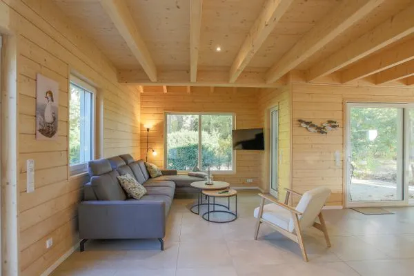 Einfamilienhaus Am Hafen 21 in Zieslow — heller Wohnbereich mit Ecksofa, Holzvertäfelung und Terrassen Zugang  Am Hafen 21