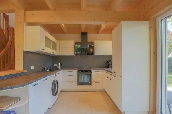 Einfamilienhaus Am Hafen 21 in Zieslow — moderne U-Küche mit Einbaugeräten, Steinrückwand und offen zum Wohnzimmer  Am Hafen 21