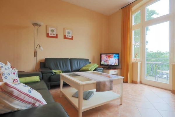 Wohnbereich mit Flachbildfernseher und Zugang zum Balkon