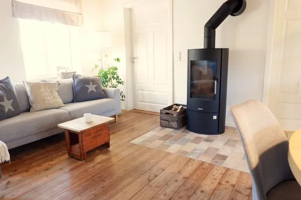 Wohnbereich mit Kaminofen (Starter-Korb Holz inkl.)  Ferienwohnung Teve im Reethus Mühlenlund