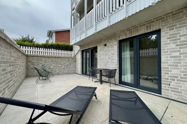 Entspannen Sie auf dieser sonnigen Terrasse mit bequemen Liegen und einem einladenden Tisch. Salt & Sand Haffkrug Salt & Sand Wohnung Sea