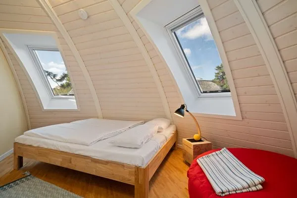 ChatGPT:Ferienhaus Nordkugel – Gemütliches Schlafzimmer mit Panoramablick unter gewölbtem Dach  Nordkugel