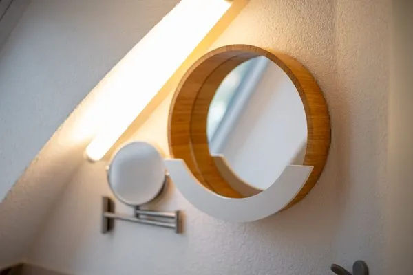 Ferienhaus Nordkugel – Kugelhaus am Tollensesee – stilvolles Detail im Bad: modernes Spiegel-Design mit warmem Licht  Nordkugel