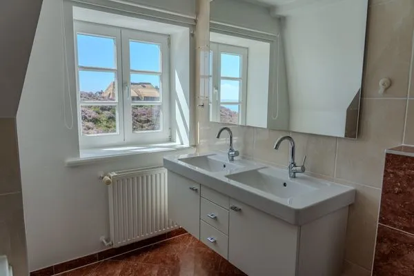 Badezimmer mit Doppelwaschbecken und Fenster  Ashley