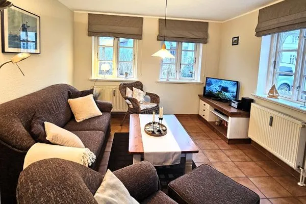 Gemütliches Wohnzimmer mit Sofa, Sessel und Fernseher.  Am Museum - Wohnung 1