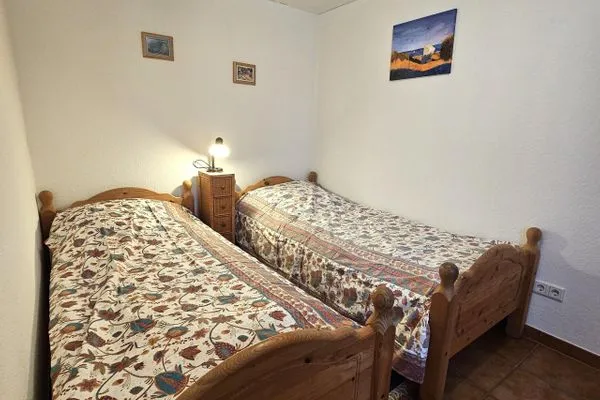 Zweibettzimmer mit Holzbetten und einem Nachttisch.  Am Museum - Wohnung 1