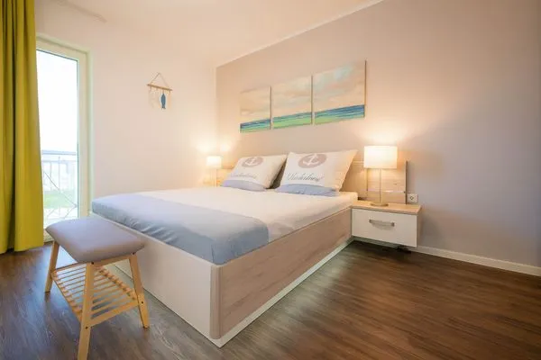 Helles Schlafzimmer mit Doppelbett und Nachtkommode  Strandnah