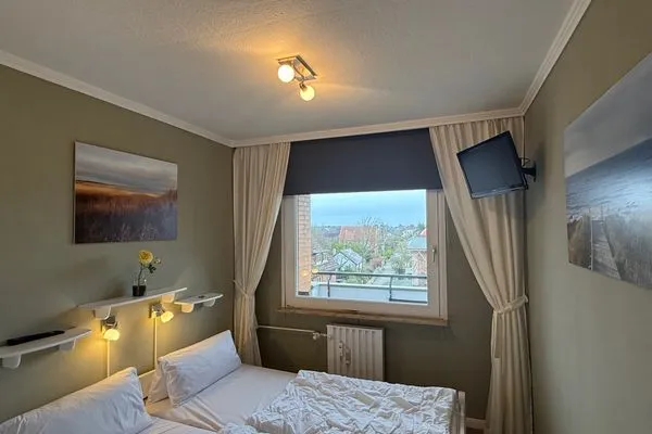 Schlafzimmer mit TV Ferienwohnung im Haus Nordland App 59