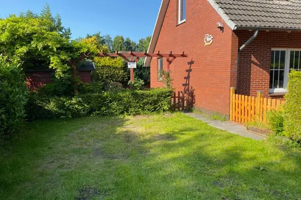 Außenansicht eines roten Hauses mit Garten  Fewo Seeschwalbe A