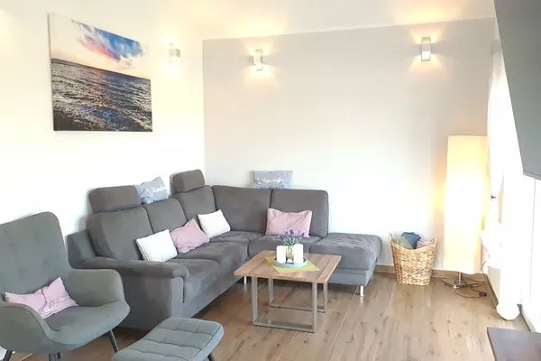 Gemütliches Wohnzimmer mit grauer Couch  Ferienhaus  Deichoase