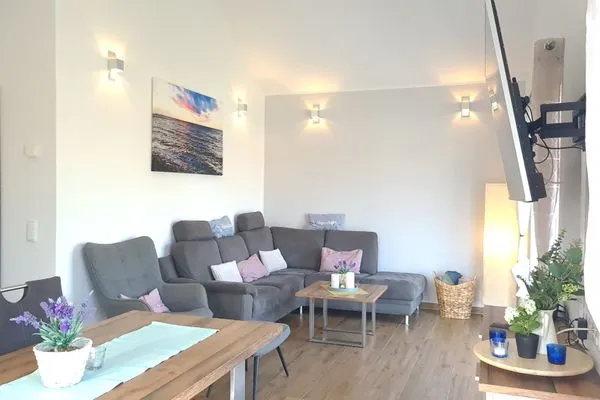 Gemütliches Wohnzimmer mit Sofa und Esstisch  Ferienhaus  Deichoase