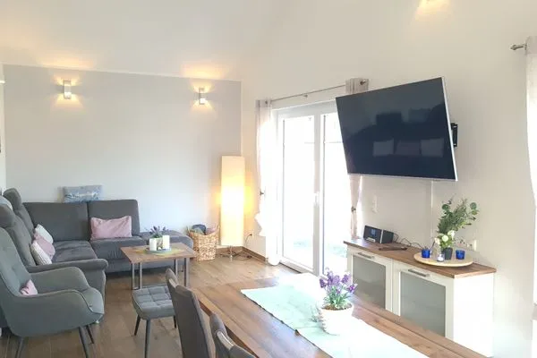 Helles Wohnzimmer mit Sofa und Fernseher  Ferienhaus  Deichoase