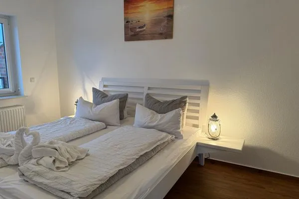 Doppelbett mit Nachttischlampe, TV Haus Landweg 15 Wohnung 4