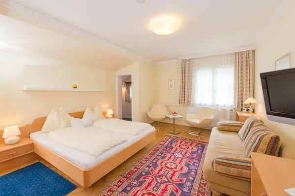 Schlafzimmer 1, Doppelbett, Sofa und Fernseher  City Life 4 by Alpenidyll Apartments