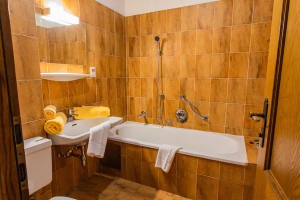 Bathroom with a bathtub and toilet  Huberhof 8 by Alpenidyll Apartments