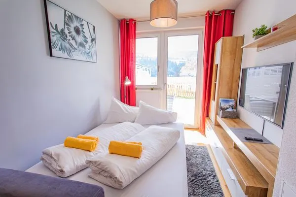 Living room with a sofa bed and access to the terrace  Sunny Aich by Alpenidyll Apartments