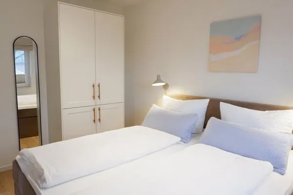 Schlafzimmer mit Boxspringbett und Kleiderschrank  Ferienhaus Landliv Stuuv