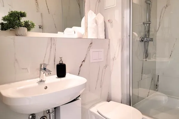 Sauberes modernes Badezimmer mit WC und Dusche  Charmantes Appartement am Hafen mit gratis Bettwäsche-Paket und Terrasse