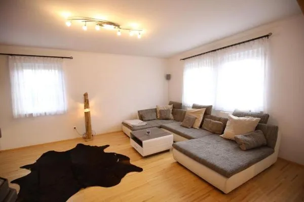 Wohnzimmer mit Schlafsofa und Fernseher  Ferienhaus Aich by Alpenidyll Apartments