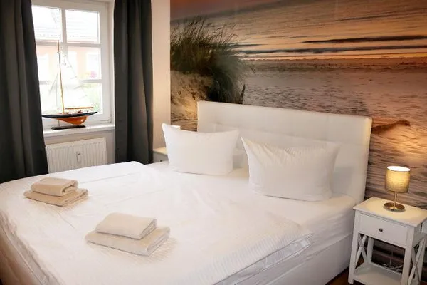 Schlafzimmer mit Doppelbett und Kleiderschrank (Kinderreisebettchen ist vorhanden), Insektenschutzgitter am Fenster  Kormoran