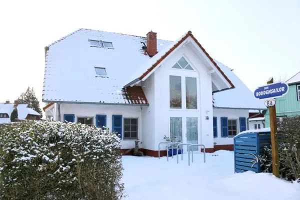 Außenansicht mit PKW-Stellplatz vor dem Haus im Winter  Kormoran