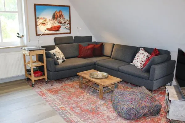 Wohnbereich mit Couch und TV Zum Leuchtturm Wohnung 9