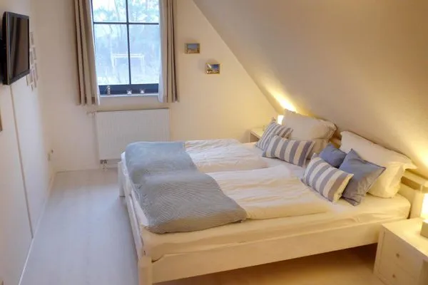 Schlafzimmer im Obergeschoss mit Doppelbett und Flachbild-TV  Morgensünn