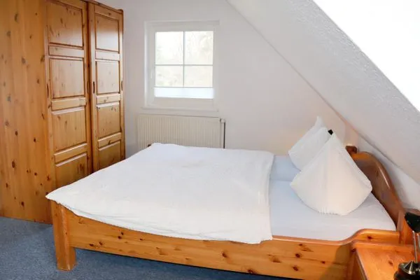 Doppelbett und Kleiderschrank im Schlafbereich Haus Kleist Zimmer 5