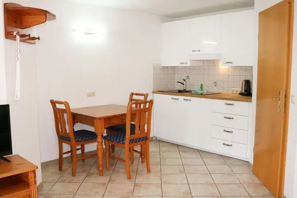 Küchenbereich mit Esstisch und Platz für drei Personen Haus Kleist Wohnung 1