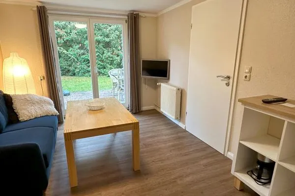 Wohnzimmer mit Couch, TV und Zugang zur eigenen Terrasse Haus Kleist Wohnung 3