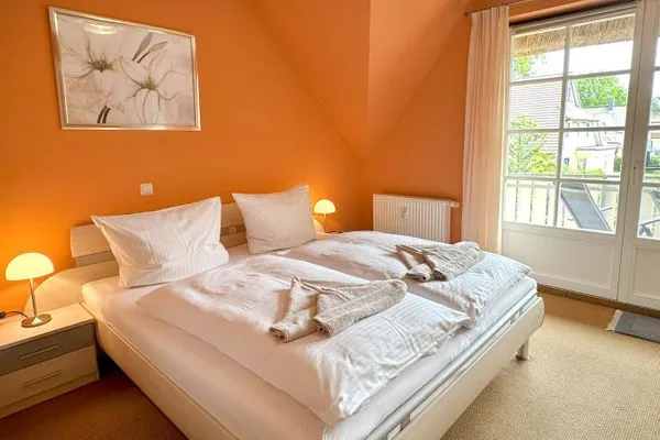 großes Schlafzimmer mit Kleiderschrank, Kommode und Zuganz zum Balkon  Deichrose W9
