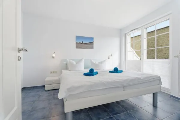 Schlafzimmer mit Doppelbett und Balkon  de Obendtied - Wohnung 4