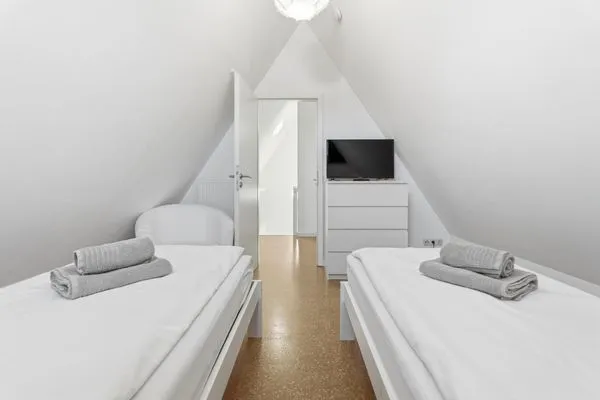 Schlafzimmer mit zwei Einzelbetten und TV  Rosenberg-Siedlung 21a/2