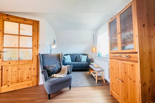 Wohnzimmer mit Sofa und Lesesessel, TV und Büchern  Nordkiek No. 8