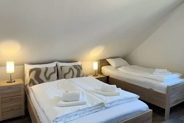 Ansicht Schlafzimmer mit Doppelbett und Einzelbett  Küstenperle Haffkrug - dein Platz am Meer